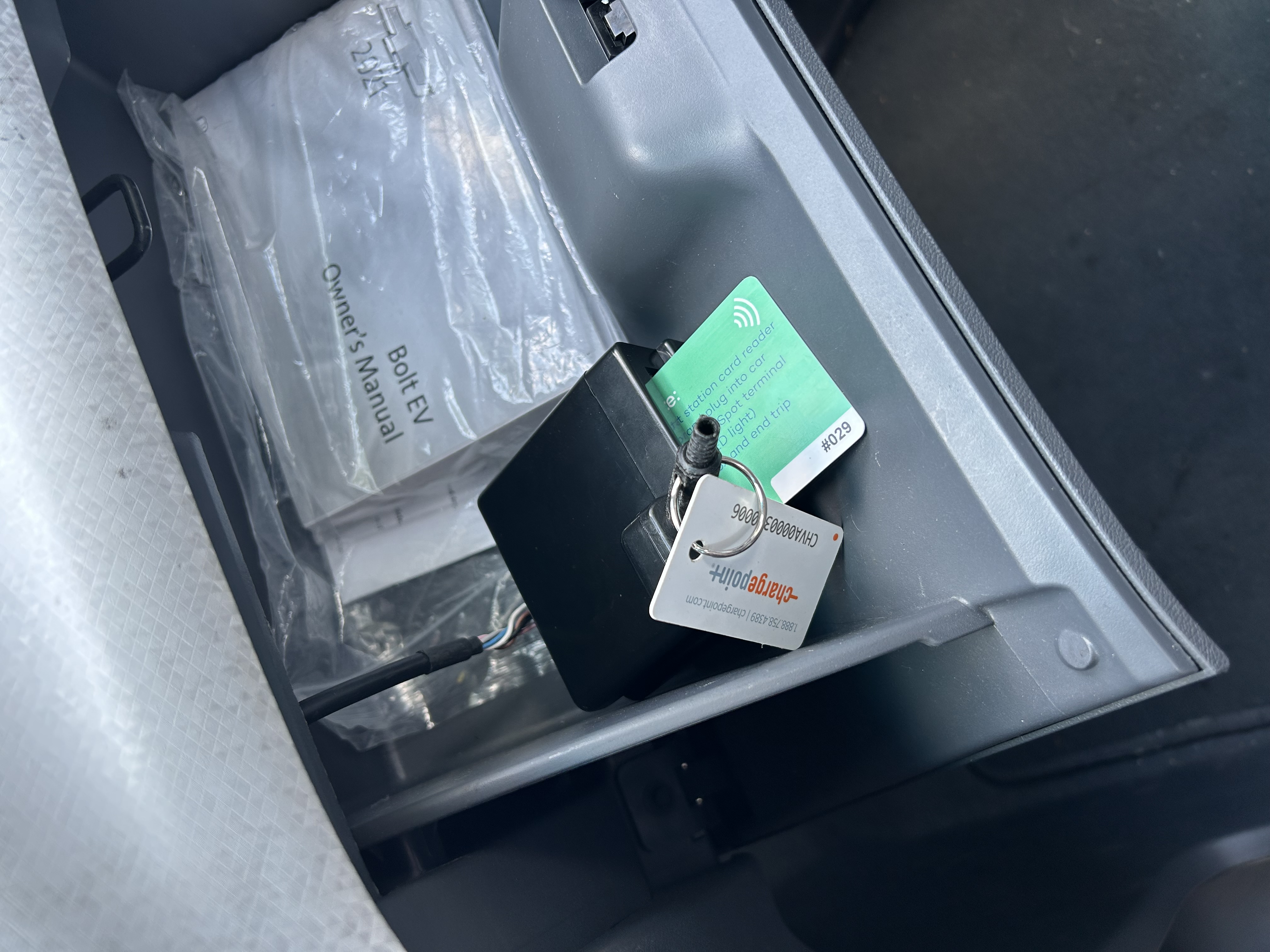 A picture of an Evie glovebox with two charge cards in it.