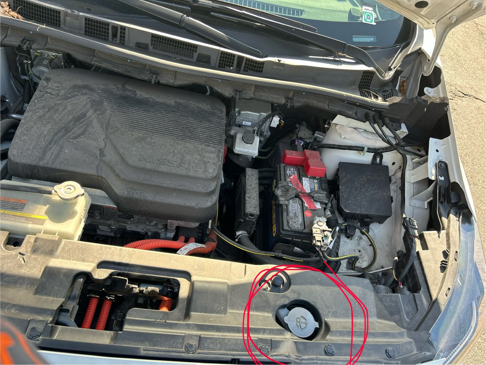 A picture showing where to put wiper fluid in a Nissan Leaf.