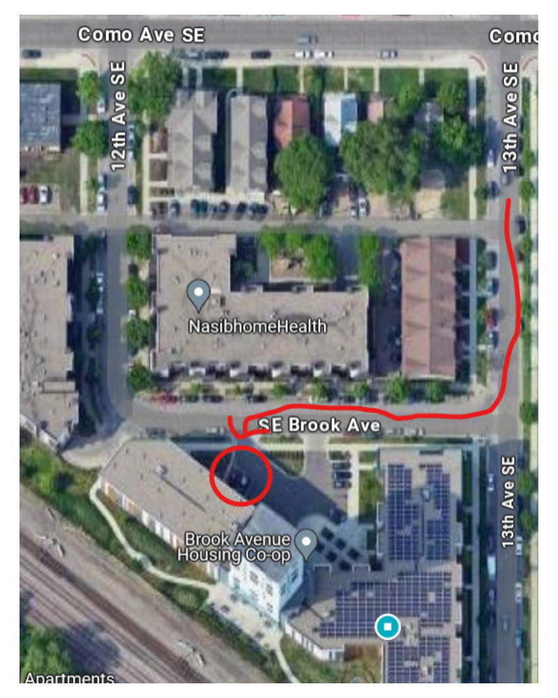 An overhead view of the Maya Commons hub and surrounding area: the charger and two spots are circled on the West side of the parking lot in front of the building.